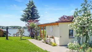 A house with a garden, a wooden deck, and a view of a lake. - Lovely home in Lychen with sauna (Lychen)