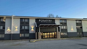 A Country Inn & Suites by Radisson building with a modern facade, large windows, and a covered entrance.