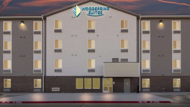 A multi-story hotel with a sign reading "Woodspring Suites" and a fire lane marking. - Woodspring Suites Waco South (Waco)