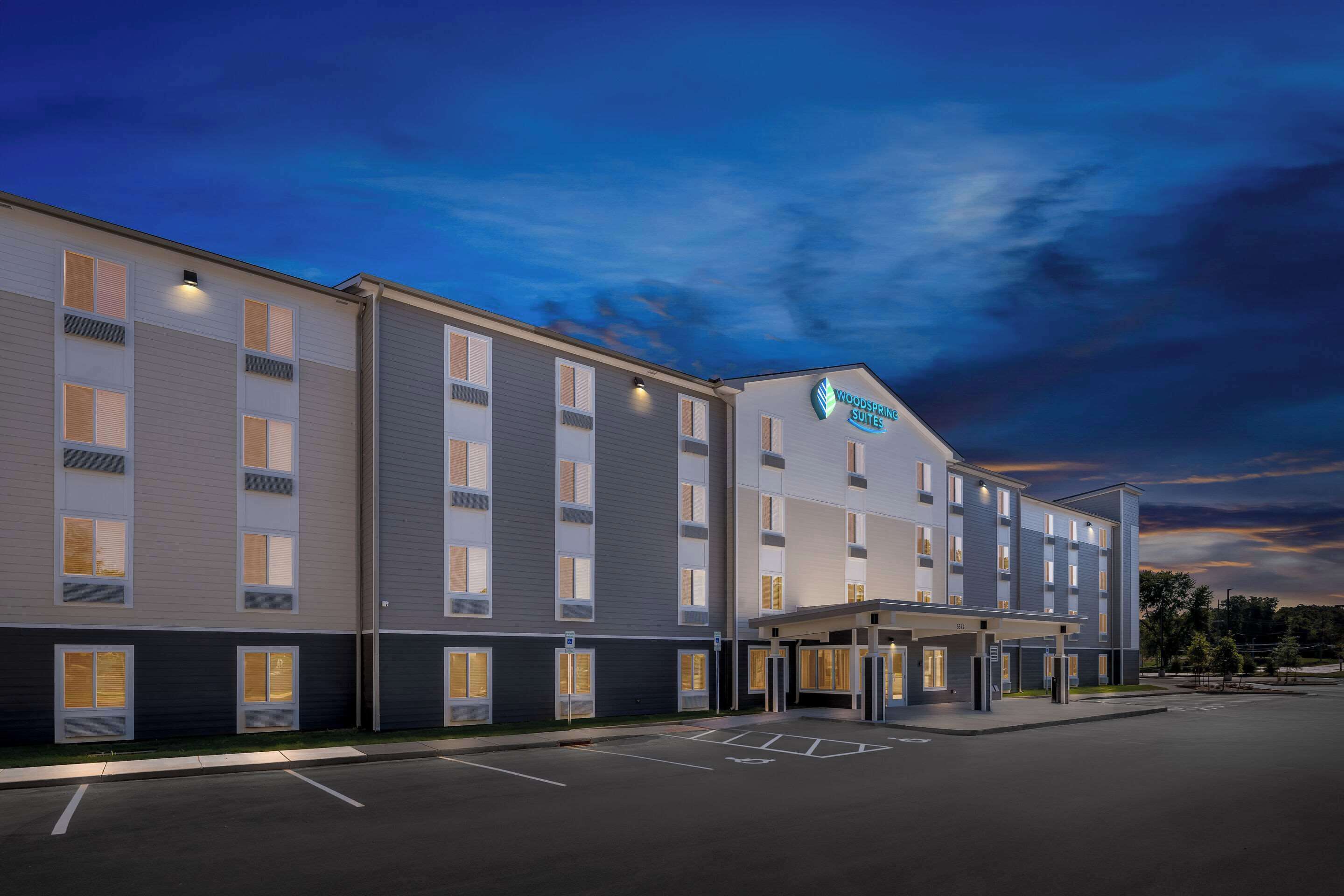 Ein modernes Hotel mit flacher Fassade, mehreren Eingängen und einem Parkplatz.