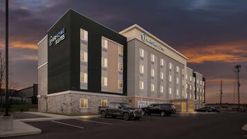 A hotel with a modern design, featuring a prominent sign for 'Everhome Suites'.