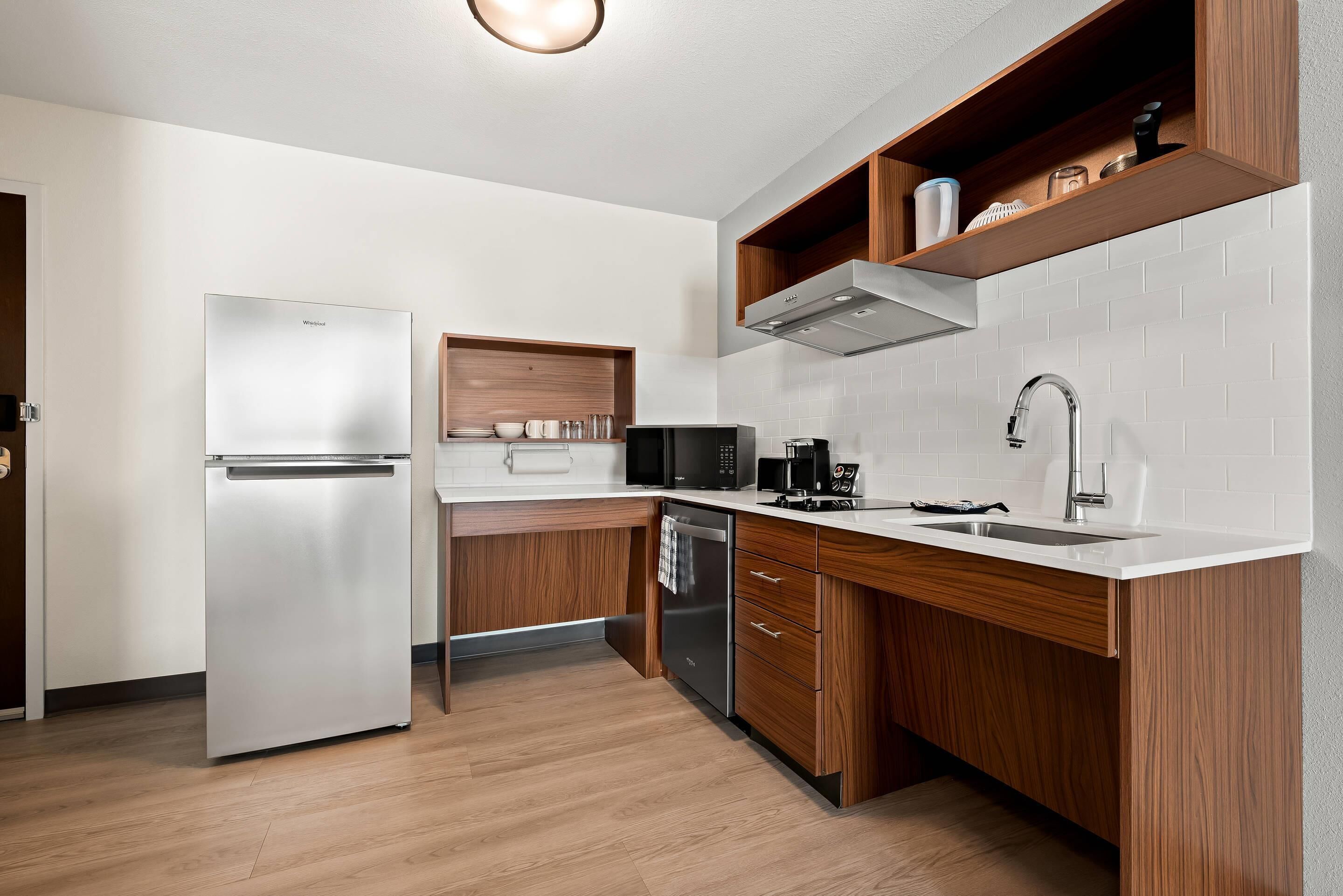 A modern kitchen with a built-in refrigerator, microwave, and dishwasher.