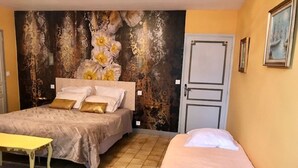 A bedroom with two beds, a bench, and a decorative wall. - Studio 3 Personnes Dans Environnement de Charme (Caudrot)