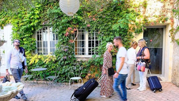 A courtyard with a stone floor, a fountain, and a building covered in ivy. - Studio 3 Personnes Dans Environnement de Charme (Caudrot)