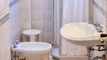Een badkamer met toilet, bidet en wastafel.