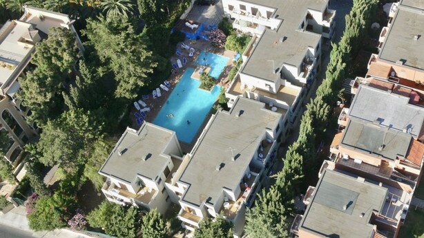 Vista aérea de una zona residencial con piscina central rodeada de casas.