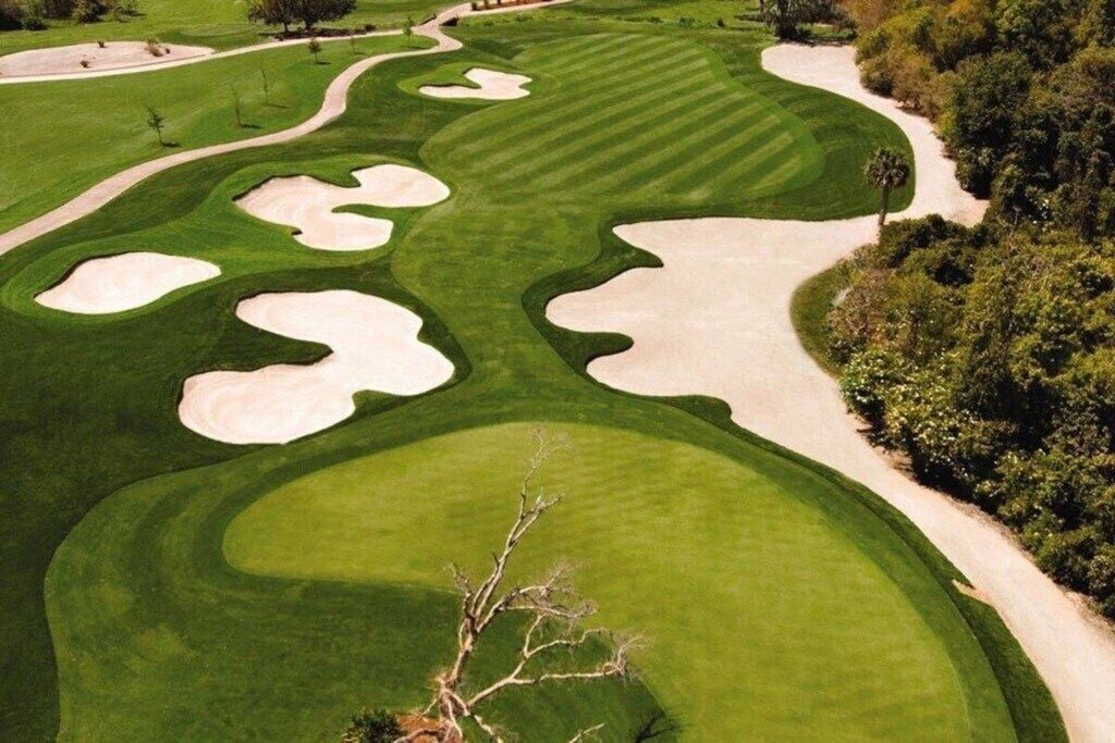 Un parcours de golf doté de bunkers de sable, d’une pelouse bien entretenue et d’un sentier sinueux.