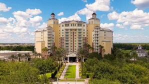A large, multi-story hotel with a symmetrical facade, central entrance, and surrounding greenery. - High-End 4BD in Luxury Reunion Resort 6mi Disney! (Kissimmee)
