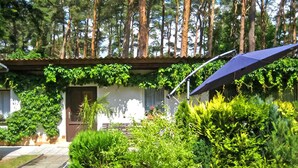 A house with a garden, a door, and a blue umbrella. - Ferienhaus Lubmin (Seebad) (Lubmin (Seebad))