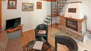 Ein Wohnzimmer mit Fernseher, Kamin und Treppe.