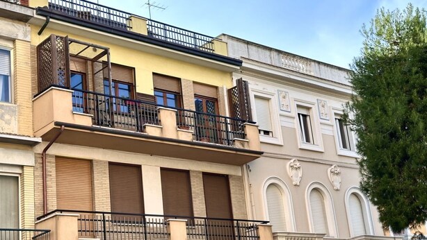 Um edifício de vários andares com varandas, janelas amplas e estilo arquitetônico clássico.