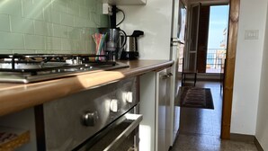 Cozinha equipada com fogão, forno e máquina de café.