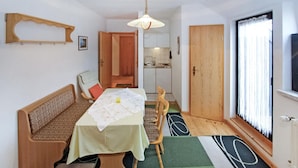 Un ambiente compatto con angolo ristoro, angolo cottura e bagno piccolo.