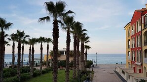A coastal hotel with palm trees, a beach view, and colorful buildings. - P024 - Porto Recanati, new three-room apartment facing the sea (Porto Recanati)