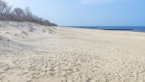 A sandy beach with a clear sky and a distant pier. - Gorgeous home in Sarbinowo with WiFi (Sarbinowo)