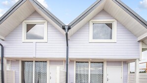 A two-story house with a gable roof, a central chimney, and a garage door. - Gorgeous home in Sarbinowo with WiFi (Sarbinowo)