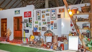 A room with a rustic decor, featuring a wooden door, a wall adorned with various framed pictures, and a shelf with kitchen utensils and bottles. - Ferienwohnung Wokuhl-Dabelow (Wokuhl-Dabelow)