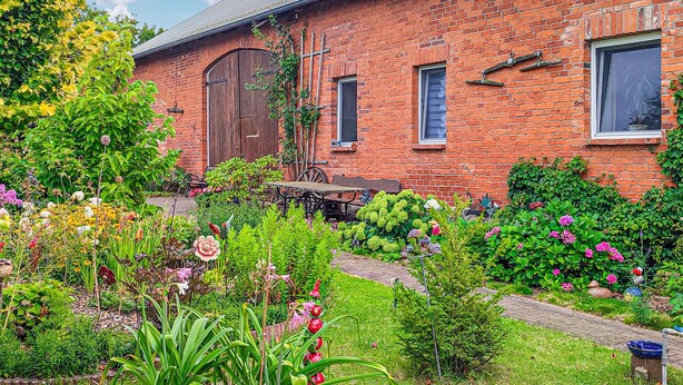 A brick house with a garden in front. - Ferienwohnung Wokuhl-Dabelow (Wokuhl-Dabelow)