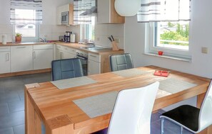 Enjoy meals in a bright and airy setting with a central island and large window offering a view of the surrounding greenery.