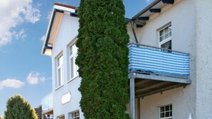 Un edificio de varios pisos con un balcón y un toldo a rayas.