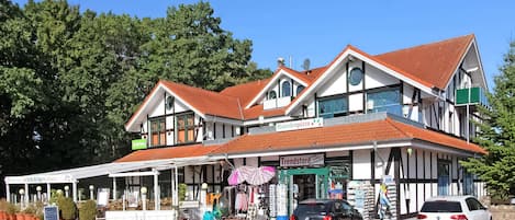 En tvåvåningsbyggnad med en traditionell arkitektur, kännetecknad av ett rött tegeltak och vita väggar.