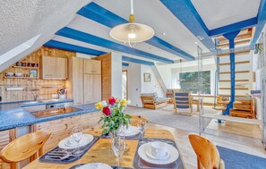 A spacious loft-style room with a kitchen, dining area, and a large window. - Ferienwohnung Pruchten (Pruchten)