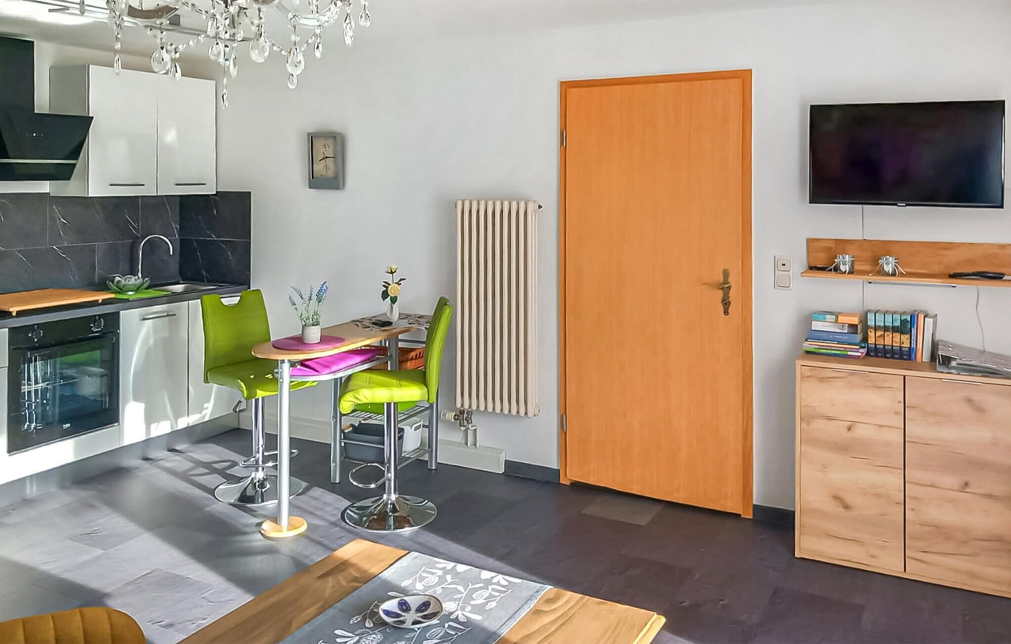 Eine moderne Küche mit Backofen und einem Essbereich mit Tisch und Stühlen.