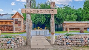 Une pancarte en bois portant l’inscription « BÜRGERTEN » est placée à l’entrée d’une propriété.