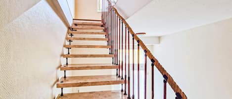 Una escalera de madera con barandales de metal.