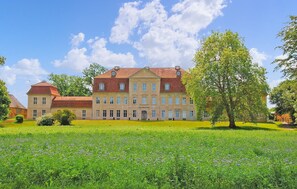 A large, historic building with a symmetrical facade, multiple windows, and a central entrance. - Cozy home in Kummerow with sauna (Kummerow)