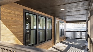 Eine Veranda mit Holzverkleidung und einem Metallgeländer.
