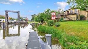 Ein Kanal mit Schleusen, einer Brücke und einem Haus mit Balkon.