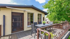 Ein Gebäude mit Balkon, Tisch und Stühlen.