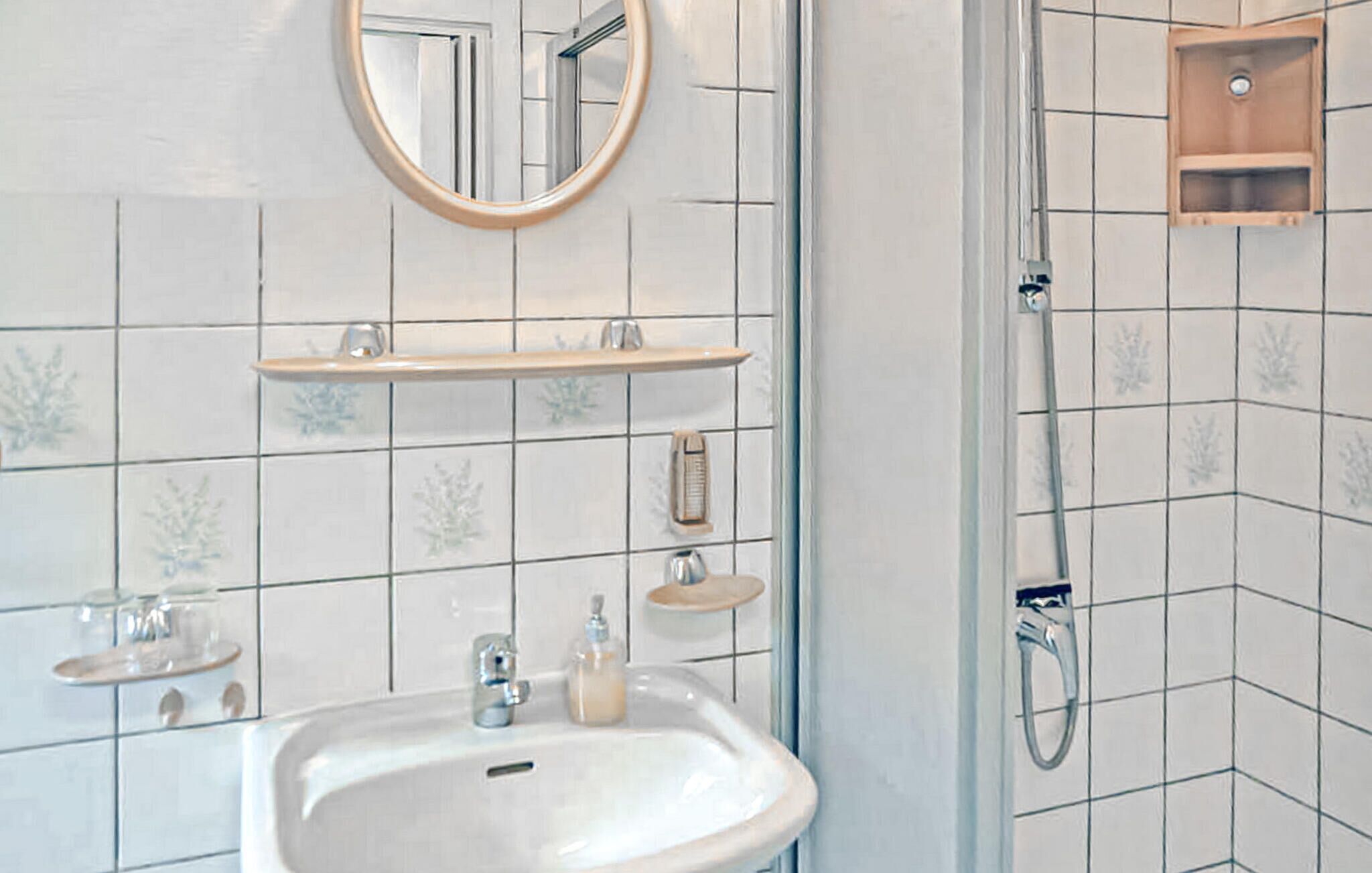 Une salle de bain avec un lavabo, un miroir et une douche.