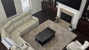 Una sala de estar moderna con un sofá modular, una mesa de centro y una chimenea.