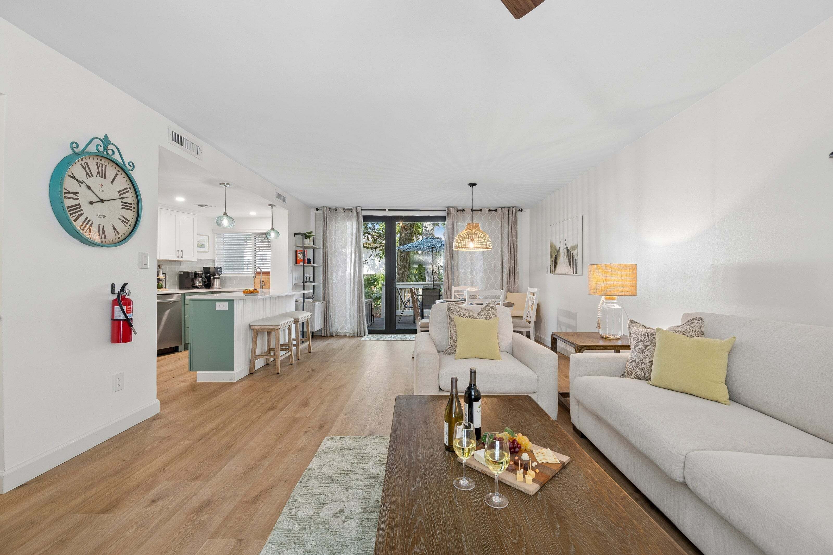 A modern living room with a sofa, coffee table, and a dining area with a table and chairs.