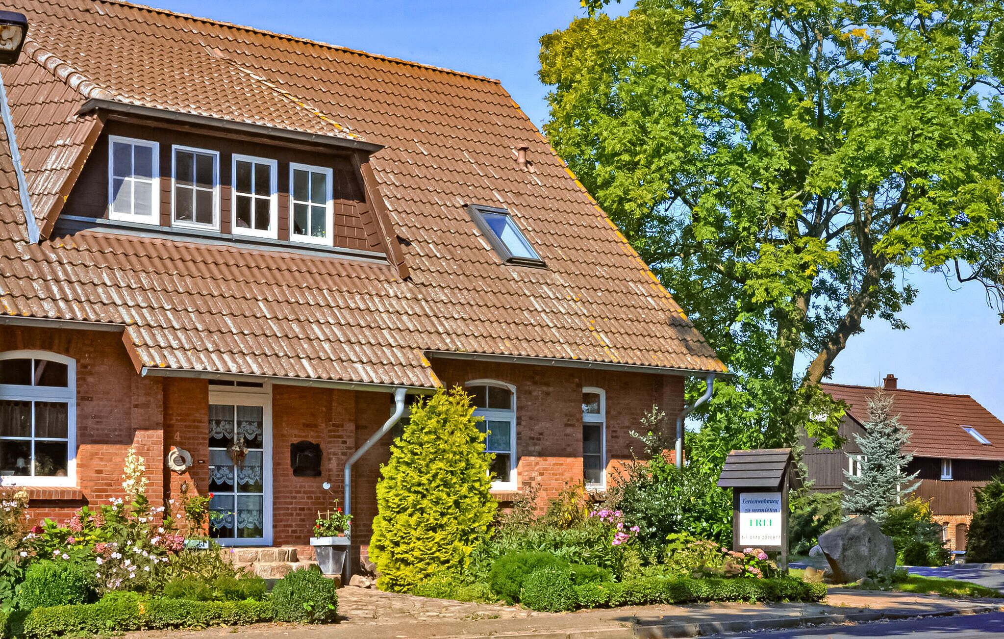 A two-story house with a sloped roof, brick exterior, and multiple windows.