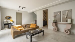 Un salon moderne avec un canapé, une table basse et des œuvres d’art accrochées au mur.