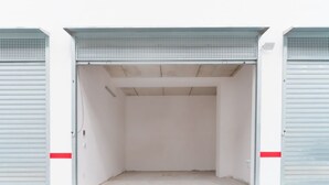 A large, empty industrial-style garage with metal doors and a concrete floor.