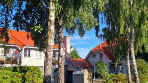 A residential area with houses, a garage, and a sign indicating a public toilet. - Birkenstr. 14 Wg.2 "timeout Oasis" - Entspannung Pur: Timeout Oasis Ferienwohnung in Strandnah (Zingst)