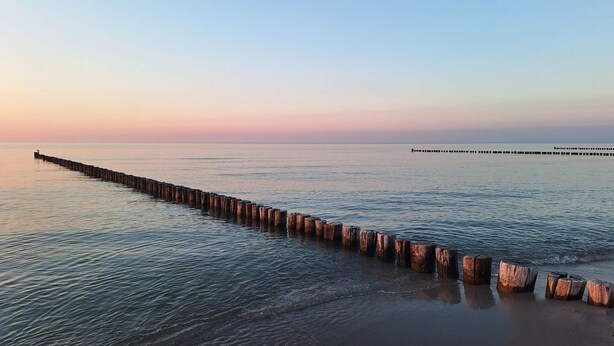 A long wooden pier extending into calm waters at sunset. - Birkenstr. 14 Wg.2 "timeout Oasis" - Entspannung Pur: Timeout Oasis Ferienwohnung in Strandnah (Zingst)
