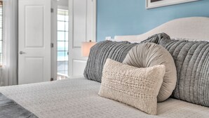 A bedroom with a bed, pillows, and a wall-mounted painting. - Ocean View Haven - Walk to the Beach (Lincoln City)