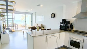 Una cocina moderna con armarios blancos, encimera de granito y horno empotrado.