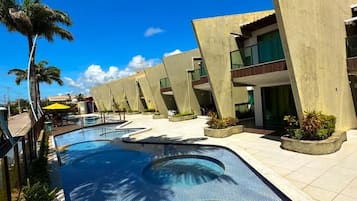 Una piscina de diseño curvo, rodeada de edificios modernos con balcones y zonas de estar al aire libre.