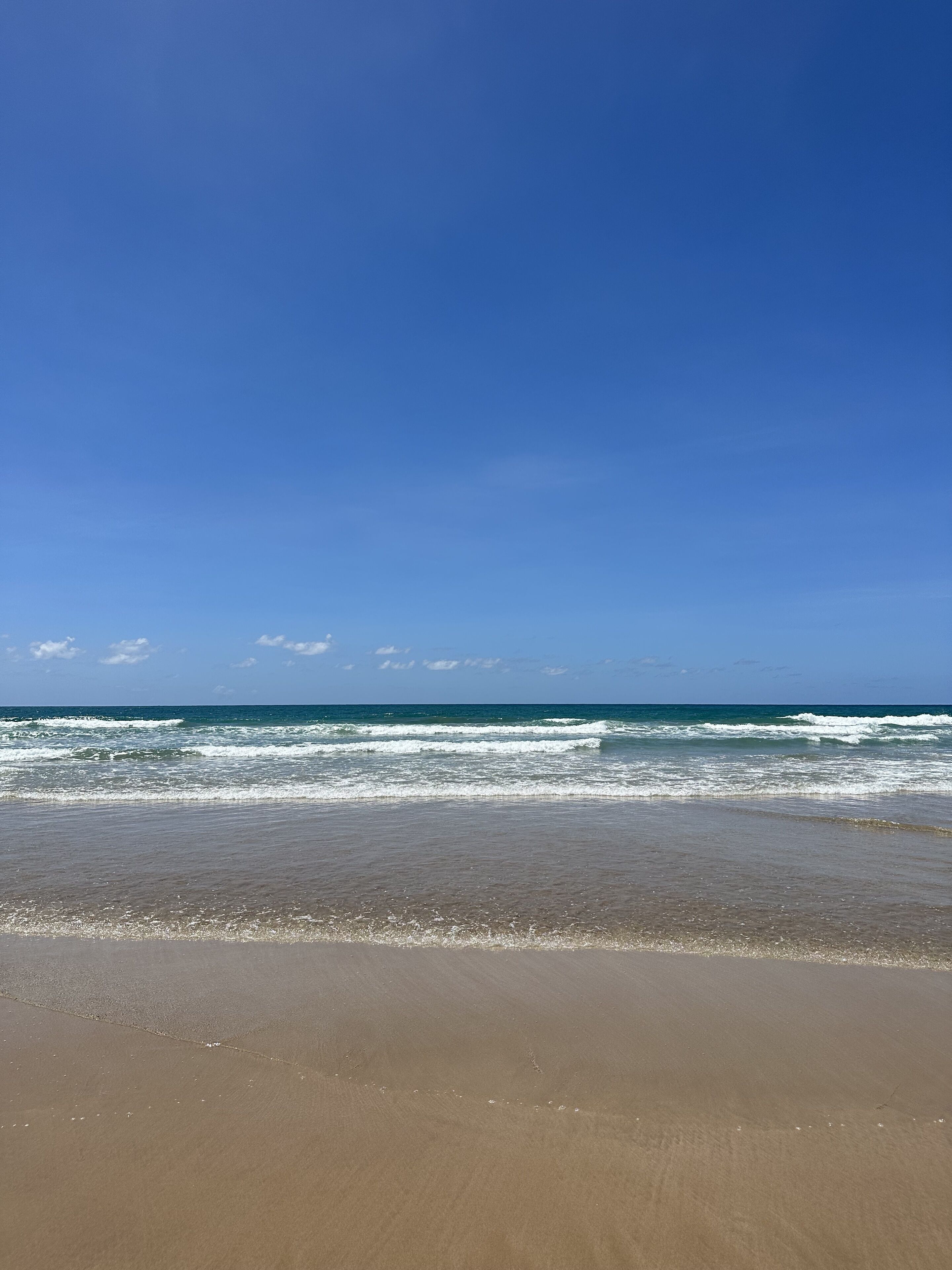 A beach with clear skies and waves.