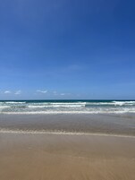 Una playa con cielos despejados y olas.
