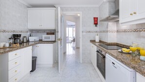 A modern kitchen with white cabinets, granite countertops, and a microwave. - Paseo del Mar (Javea / Xàbia)