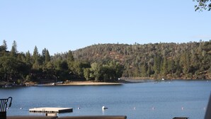 A lakeside view with picnic tables and a dock. - Sierra Breeze - Your Yosemite Adventure Base Camp In Pine Mountain Lake (Groveland)