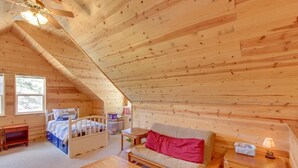 A cozy attic bedroom with a wooden ceiling, a bed, a sofa, a small table, and a nightstand. - Sierra Breeze - Your Yosemite Adventure Base Camp In Pine Mountain Lake (Groveland)