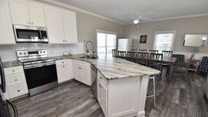 Una cocina moderna con armarios blancos, electrodomésticos de acero inoxidable y una isla grande.